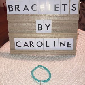 One homemade teal bracelet with bike charm